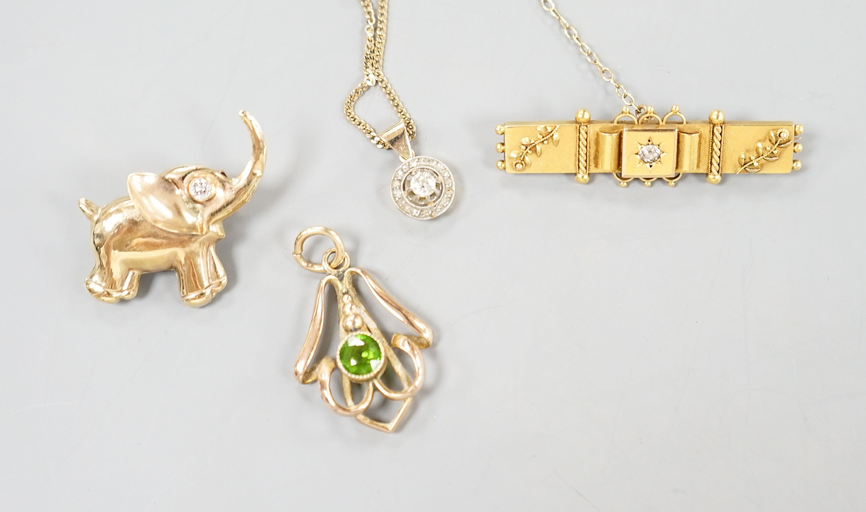A yellow metal and diamond set clasp, now mounted as a pendant on later 9k chain, a yellow metal and diamond set elephant brooch, 31mm, a yellow metal and green stone doublet set pendant and a 15ct and diamond set bar br
